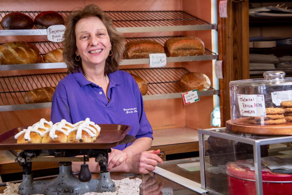 Kathy Young, the co-owner of Varrelmann's Bake Shop in Rutherford, poses with a tray of hot cross buns in the bakery on Tuesday March 29, 2022. 