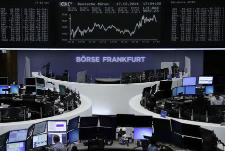 Traders are pictured at their desks in front of the German share price index DAX board at the Frankfurt stock exchange December 17, 2014. REUTERS/Remote/Stringer