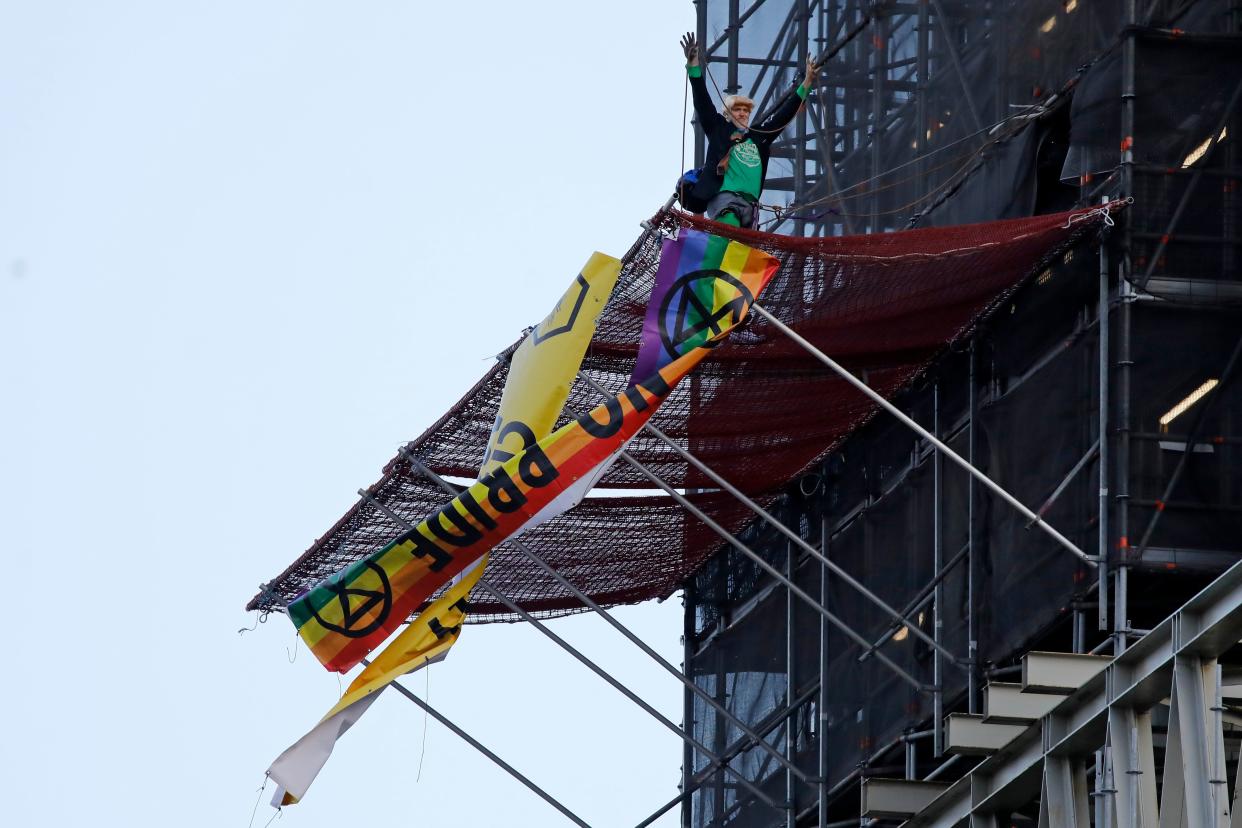 A climate activist dressed as Britain's Prime Minister Boris Johnson gestures after climbing scaffolding and unfurling banners on the Elizabeth Tower, commonly known by the name of the bell, Big Ben on the twelfth day of demonstrations by the climate change action group Extinction Rebellion, in London, on October 18, 2019. - The Extinction Rebellion pressure group has been staging 10 days of colourful but disruptive action across London and other global cities to draw attention to climate change. (Photo by Tolga AKMEN / AFP) (Photo by TOLGA AKMEN/AFP via Getty Images)