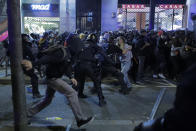 Police charge against protesters in Barcelona, Spain, Thursday, Oct. 17, 2019. Catalonia's separatist leader vowed Thursday to hold a new vote to secede from Spain in less than two years as the embattled northeastern region grapples with a wave of violence that has tarnished a movement proud of its peaceful activism. (AP Photo/Manu Fernandez)