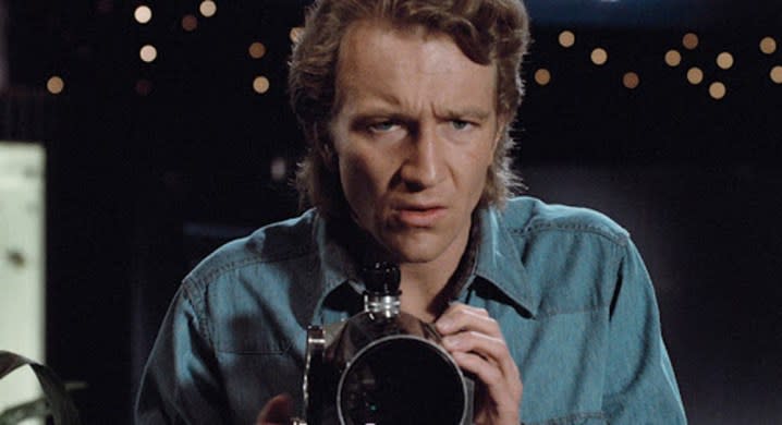 A man peers through a telescope in Body Double.