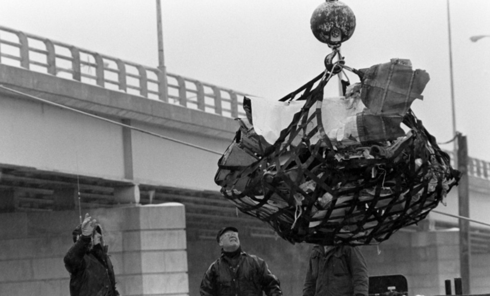 a crane lifts a load of wreckage from Flight 90