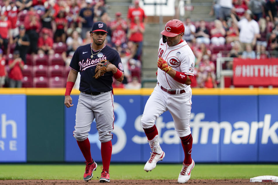 Cincinnati Reds' Joey Votto runs the bases next to Washington Nationals shortstop Luis Garcia after hitting a three-run home run during the first inning of a baseball game Thursday, June 2, 2022, in Cincinnati. (AP Photo/Jeff Dean)