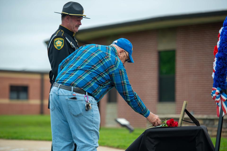 Terry King leaves a rose for his grandfather Deputy Joe Edwards during the National Law Enforcement Memorial Service at Madison County Sheriff's Office in Denmark, Tenn. on Friday, May 19, 2023. 