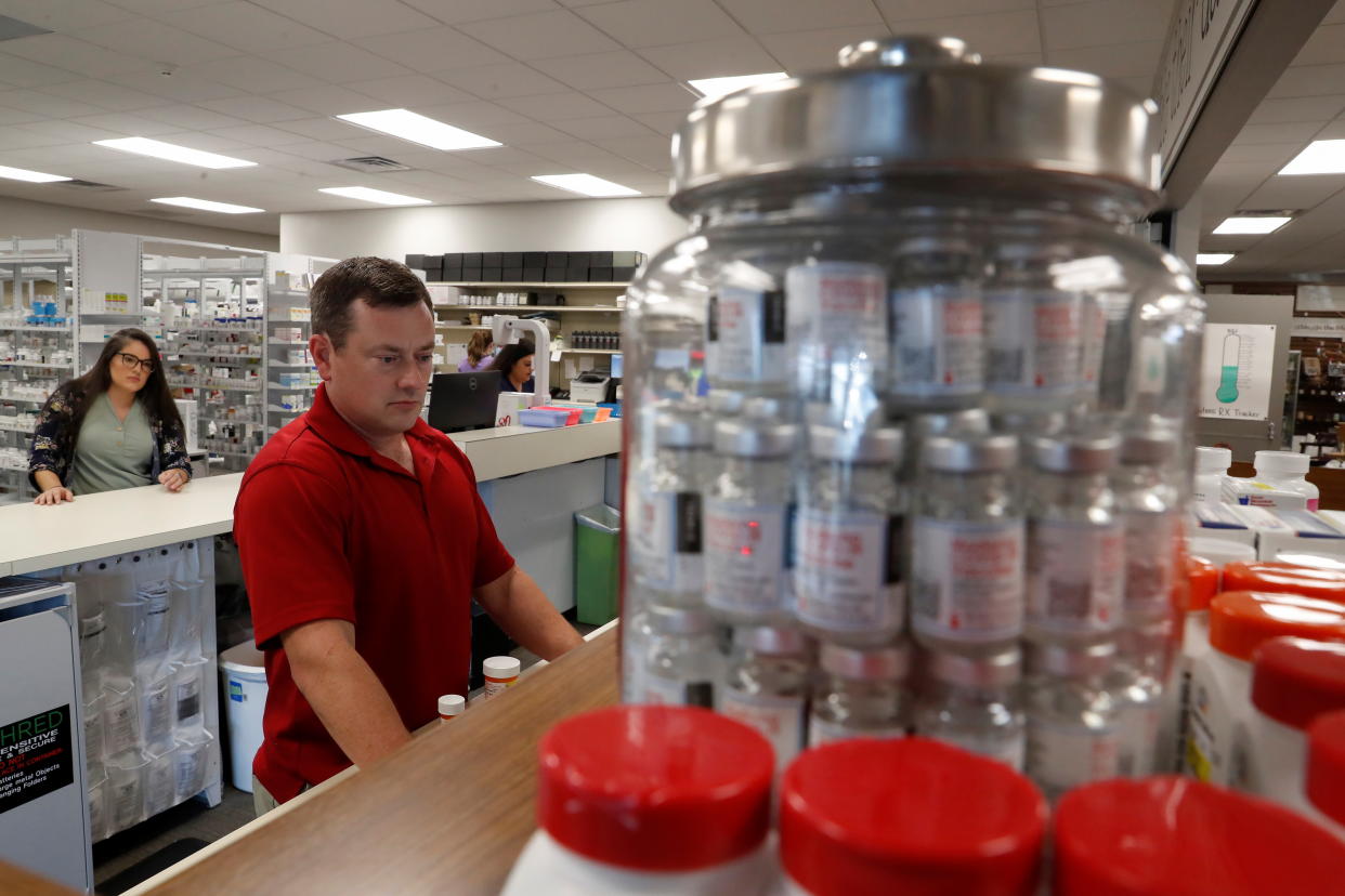 Pharmacist Daniel Bryant works behind the counter, amid the coronavirus pandemic, at the Watson Pharmacy in Fordyce, Arkansas, August 12, 2021. REUTERS/Shannon Stapleton