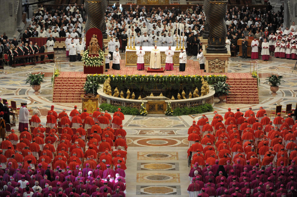 In this photo provided by the Vatican newspaper L'Osservatore Romano, Pope Francis, top center, leads a consistory inside the St. Peter's Basilica at the Vatican, Saturday, Feb. 22, 2014. Retired Pope Benedict XVI, white figure seen at center left, joined Pope Francis at a ceremony Saturday creating the cardinals who will elect their successor in an unprecedented blending of papacies past, present and future. (AP Photo/L'Osservatore Romano, ho)