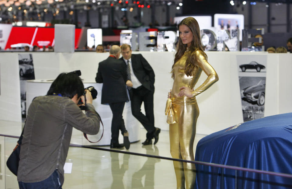 A model poses for photographers before the unveiling of the Bertone Jet 2+2 at the 2013 Geneva Motor Show.