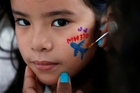 FILE PHOTO: A girl gets her face painted during the fourth annual remembrance event for the missing Malaysia Airlines flight MH370, in Kuala Lumpur, Malaysia March 3, 2018. REUTERS/Lai Seng Sin/File Photo