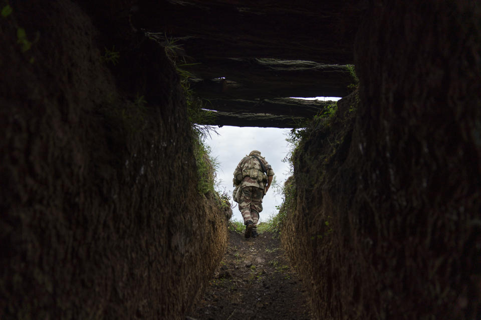 Sgt. Maj. Artur Shevtsov with the Dnipro-1 regiment exits a bunker at the unit's position near Sloviansk, Donetsk region, eastern Ukraine, Friday, Aug. 5, 2022. From a position on the outskirts of the city, soldiers with the Dnipro-1 regiment are expanding a network of trenches and digging bunkers capable of protecting soldiers against mortar strikes and phosphorous bombs. (AP Photo/David Goldman)