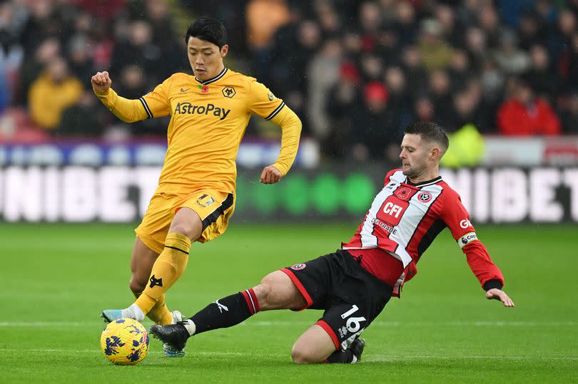 Hwang Hee-Chan is challenged by Oliver Norwood during the Premier League match between Sheffield United and Wolverhampton Wanderers at Bramall Lane.