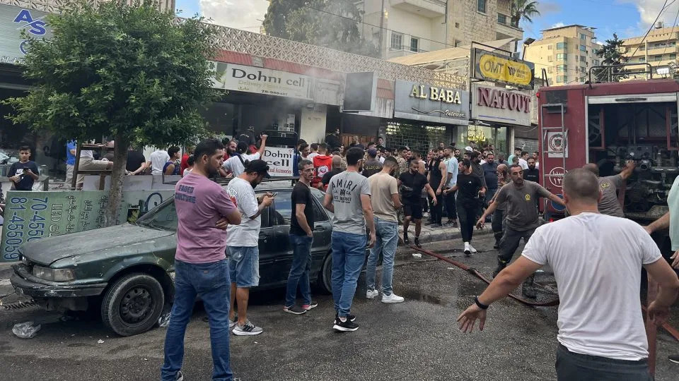 Firefighters put out flames and a crowd gathers after a reported explosion in Saida, Lebanon, on September 18, 2024. - Mahmoud Zayat/AFP/Getty Images