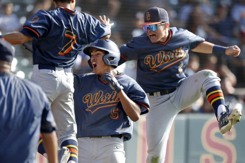 LOS ANGELES, CA - MAY 25: Octavio Bonilla (5), center, of Chatworth High, scores the winning run on a ball hit by Diego Tafolla (18), in the top of seventh inning against Roosevelt in the City Section Open Division baseball semifinal at Dedeaux Field on the campus of the University of Southern California on Wednesday, May 25, 2022 in Los Angeles, CA. Tafolla is flaked by teammates Barry Menjivar (7), left, and Dominick Camas (6). Chatsworth won 4-3. (Gary Coronado / Los Angeles Times)