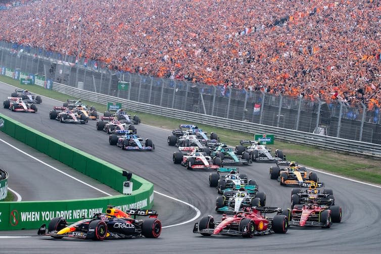 Formula One cars bunched up at a corner.