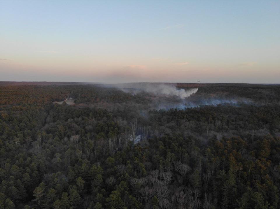 A Rhode Island National Guard helicopter drops water on the fire Wednesday.