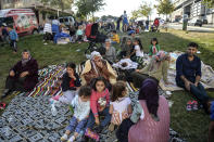 People sit in a grassy area after evacuating their homes, following an earthquake in Istanbul, Thursday, Sept. 26, 2019. Turkey's emergency authority says a 5,8 magnitude earthquake has shaken Istanbul with no immediate damage reported. Official Anadolu news agency, quoting the Istanbul governor's office, said there were no reports of damage. Experts have warned a major earthquake is expected to hit Istanbul, Turkey's most populous city with more than 15 million residents. (Ibrahim Mase/DHA via AP)