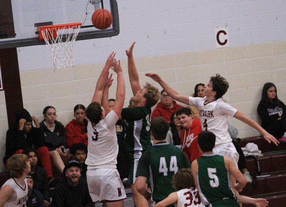 Northridge's Ethan Payne shoots from the post between Newark's Steele Meister (3) and Jake Quackenbush (4) on Tuesday.