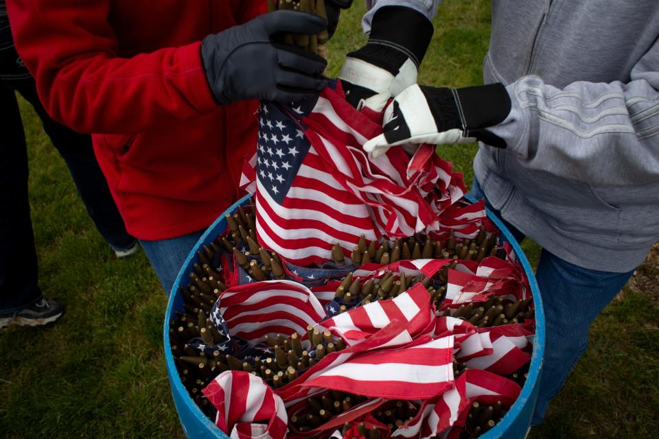 Volunteers distribute flags among headstones at the Iowa Veterans Cemetery ahead of Memorial Day on Friday, May 28, 2021, in Adel, IA. 