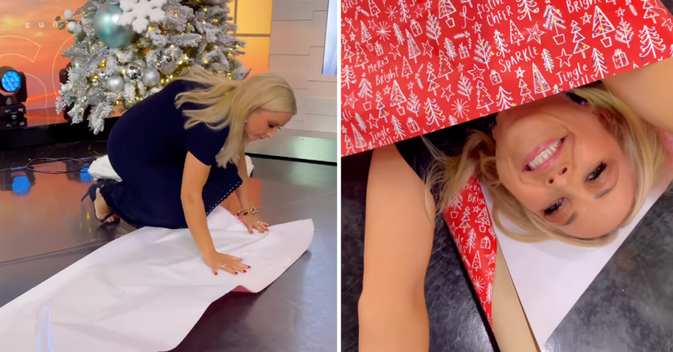 Monique Wright lays wrapping paper on the ground before rolling herself up in it. 