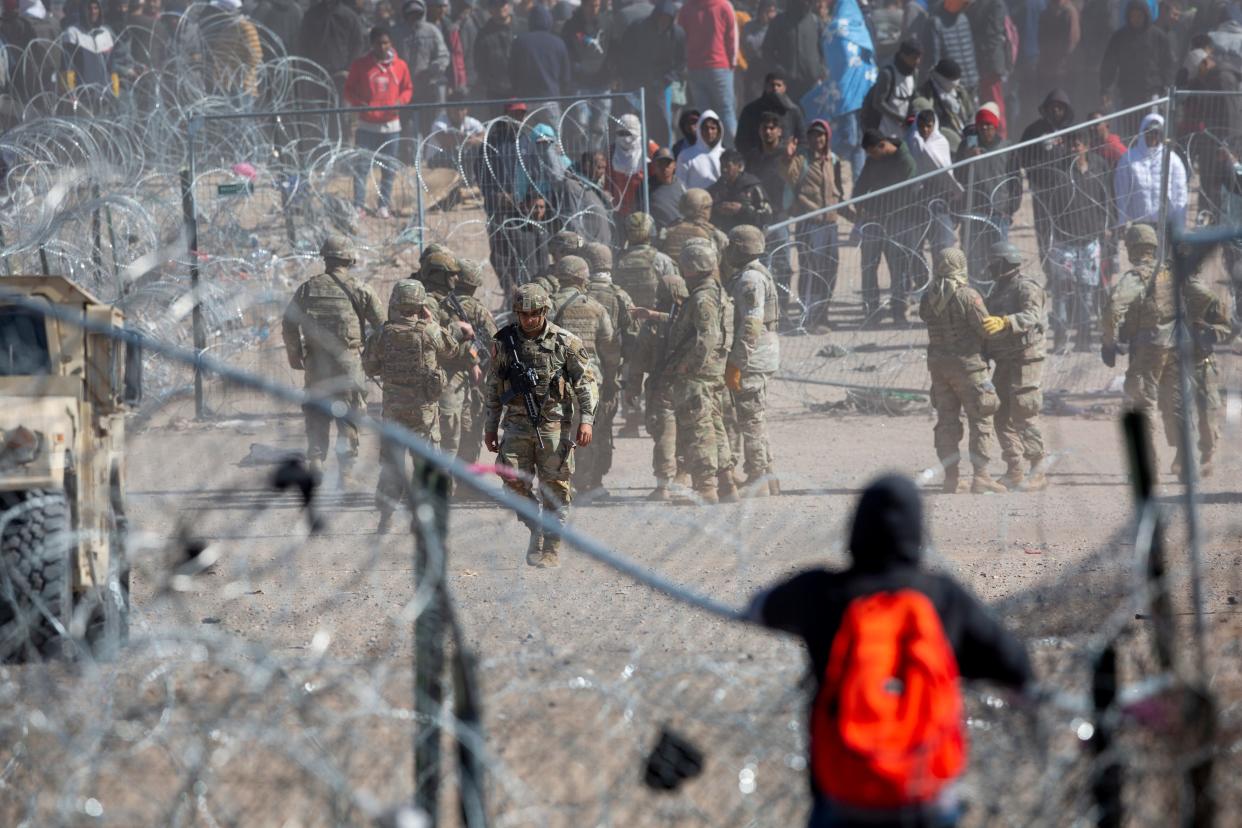 A migrant observes migrants who breached the concertina wire on the Rio Grande in El Paso, Texas on March 21, 2024. The migrants were hoping to be processed by Border Patrol.