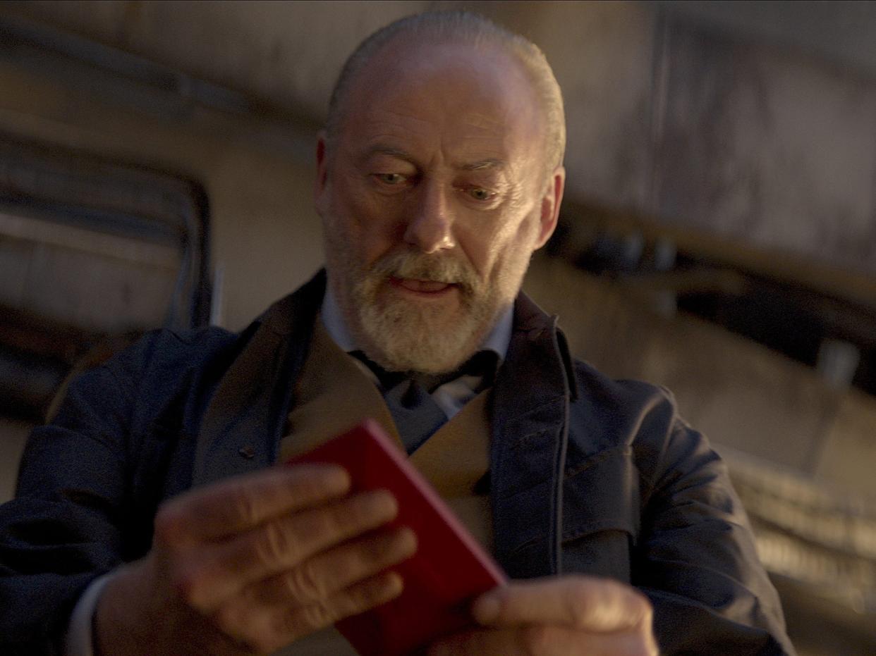liam cunningham as wade in 3 body problem, cradling a red object in his hands