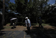 People wearing face masks to help protect against the spread of the new coronavirus walk near a park in Seoul, South Korea, Wednesday, July 15, 2020. (AP Photo/Lee Jin-man)