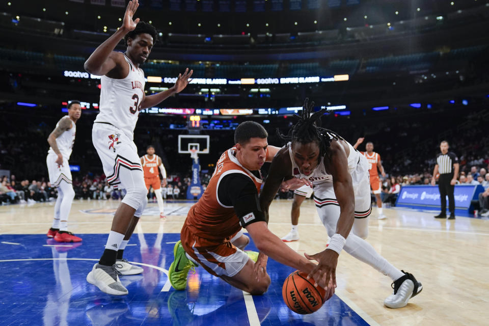 Louisville's Mike James, right, and Texas's Kadin Shedrick, center, fight for a loose ball during the second half of an NCAA college basketball game, Sunday, Nov. 19, 2023, in New York. (AP Photo/Seth Wenig)