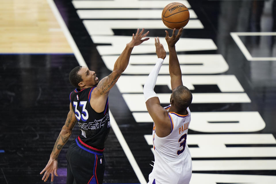 Phoenix Suns' Chris Paul, right, goes up for a shot against Philadelphia 76ers' George Hill during the second half of an NBA basketball game, Wednesday, April 21, 2021, in Philadelphia. (AP Photo/Matt Slocum)