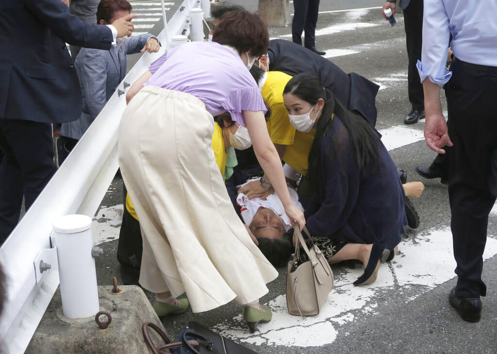 Japan’s former Prime Minister Shinzo Abe, center, falls on the ground in Nara, western Japan on Friday. - Credit: AP