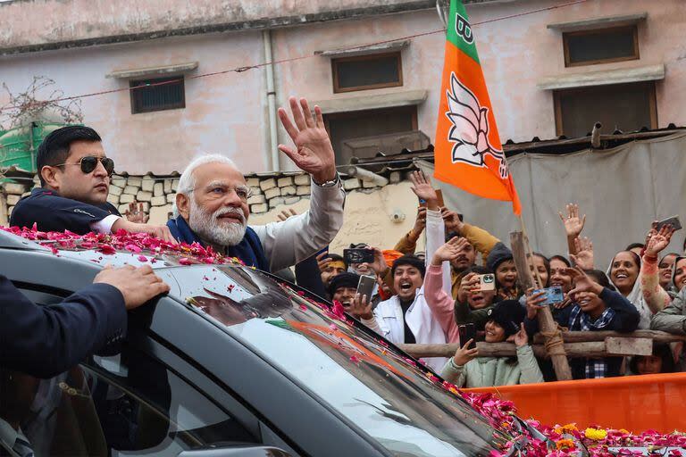 Esta fotografía proporcionada el 30 de diciembre de 2023 y difundida por la Oficina de Información de Prensa de la India (PIB) muestra al primer ministro de la India, Narendra Modi, saludando a la gente durante una caravana en Ayodhya. 