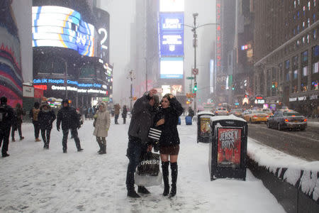 People take a selfie in Times Square on a snowy day in New York City. REUTERS/Alex Wroblewski