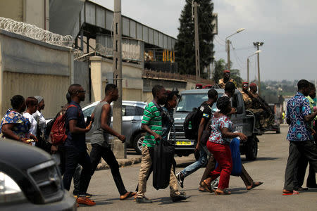 People run as they leave the port of Abidjan after hearing gunfire in Abidjan, Ivory Coast January 18, 2017. REUTERS/Luc Gnago