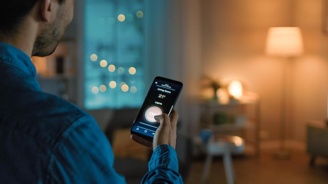  A man controlling smart lights with his smartphone 