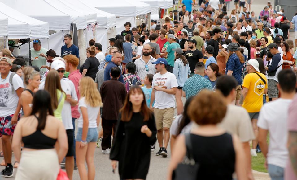 A crowd fills the street by food vendors during the 2022 Asian Night Market Festival featuring food, cultural demonstrations, a fashion show and more at Military Park in Oklahoma City.