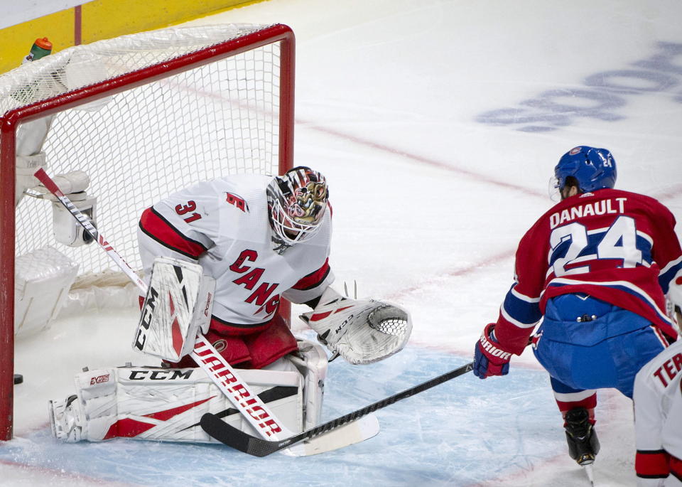 Montreal Canadiens center Phillip Danault (24) scores on Carolina Hurricanes goaltender Anton Forsberg (31) during the first period of an NHL hockey game Saturday, Feb. 29, 2020, in Montreal. (Peter McCabe/The Canadian Press via AP)