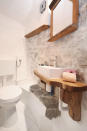 <p>The bathroom also features the beautiful wood and stone decor. (Airbnb) </p>