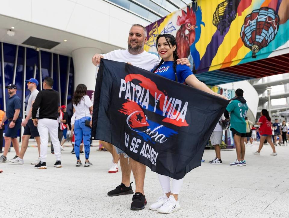 Yudith Santos and Leonardo Hernandez hold a ‘Patria Y Vida’ flag outside of loanDepot Park before the start of the semifinal game between United States and Cuba at the World Baseball Classic on Sunday, March 19, 2023, in Miami, Fla.