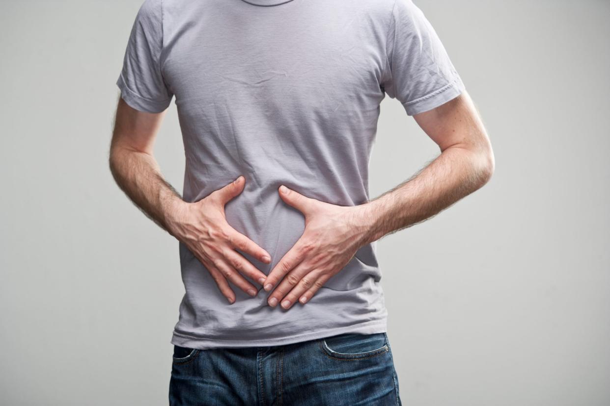 cropped shot of man's midsection on gray background