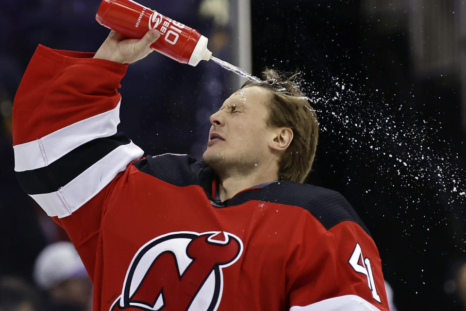 New Jersey Devils goaltender Vitek Vanecek sprays water on his head before taking on the Edmonton Oilers in an NHL hockey game Monday, Nov. 21, 2022, in Newark, N.J. (AP Photo/Adam Hunger)