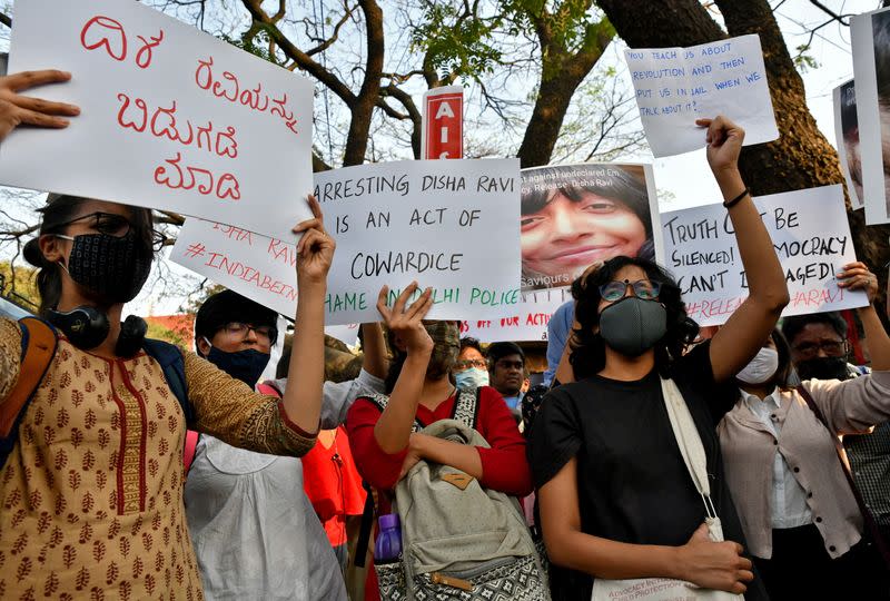 People hold placards during a protest against the arrest of 22-year-old climate activist Disha Ravi, in Bengaluru