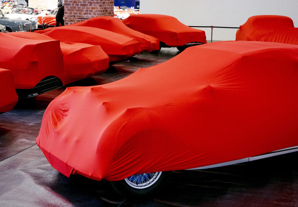 Cars are covered with red sheets ahead of the start of the IAA Auto Show in Frankfurt, Germany, Sunday, Sept. 8, 2019. (AP Photo/Michael Probst)