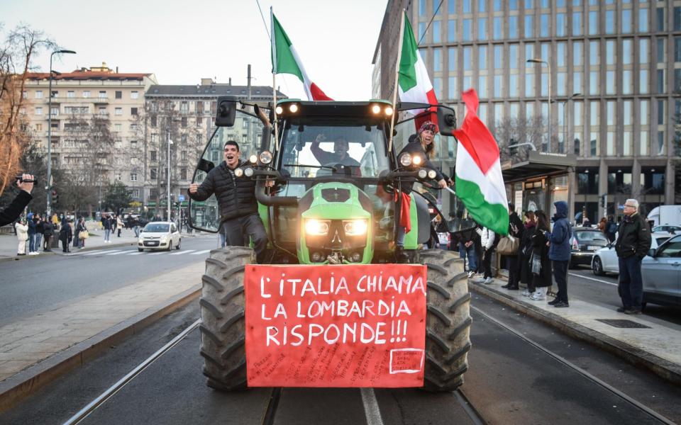 Italian farmers arrive with their tractors at the Pirelli skyscraper, seat of the Lombardy Regional Council, during a protest in Milan