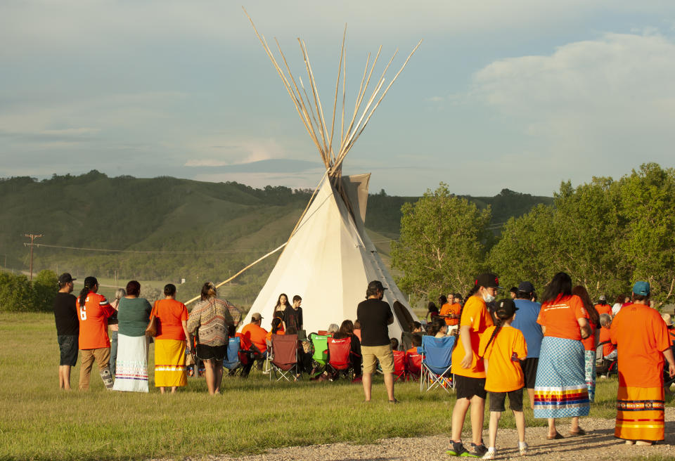 A vigil takes place where ground-penetrating radar recorded hits of what are believed to be 751 unmarked graves near the grounds of the former Marieval Indian Residential School on the Cowessess First Nation, Saskatchewan, Saturday, June 26, 2021. (Mark Taylor/The Canadian Press via AP)