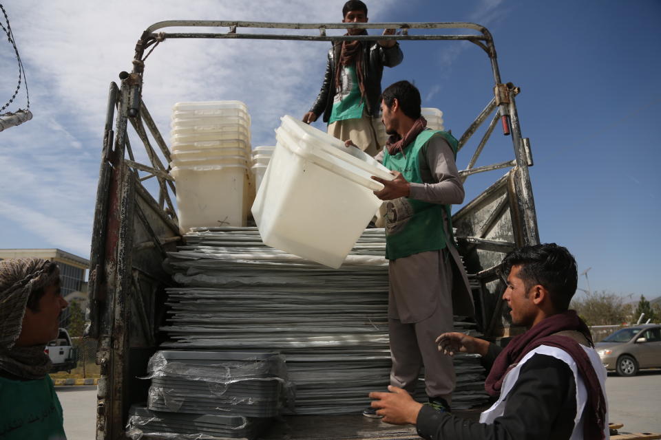 In this Wednesday Oct. 17, 2018, photo, Afghan election workers load ballot boxes and other election materials on a truck ahead of parliamentary elections, in Kabul, Afghanistan. Afghans will go to the polls on Saturday, hoping to bring change to a corrupt government that has lost nearly half the country to the Taliban. More than 50,000 security forces will be deployed to defend polling stations. (AP Photo/Rahmat Gul)