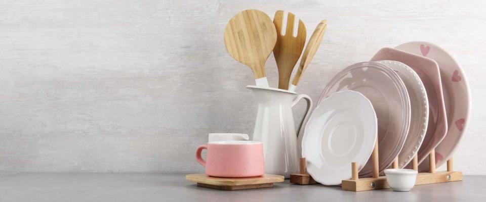 Set of kitchenware on table near light wall, space for text. Modern interior design