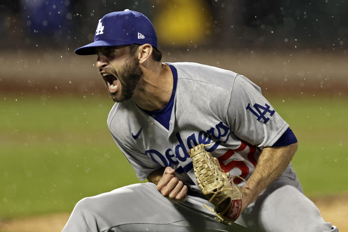 Los Angeles Dodgers' Freddie Freeman holds his batting gloves in his teeth  before the team's baseball game against the New York Mets on Tuesday, Aug.  30, 2022, in New York. (AP Photo/Adam