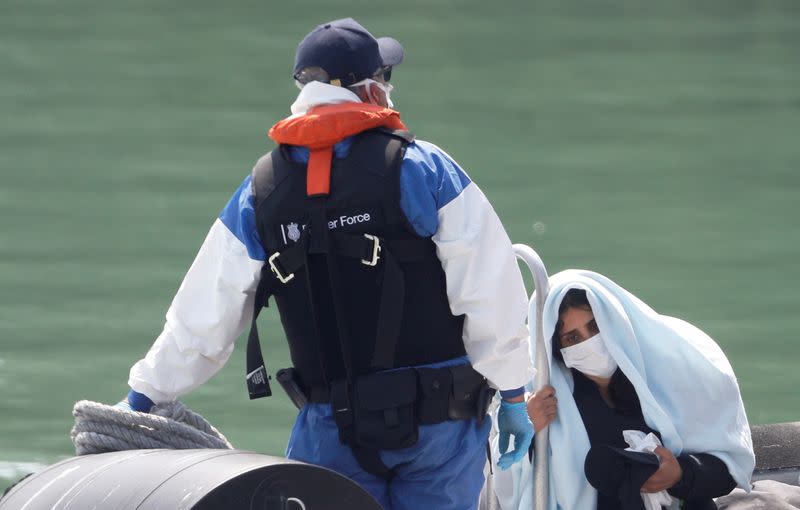 A migrant reacts while arriving to Dover harbour on a Border Force boat, in Dover