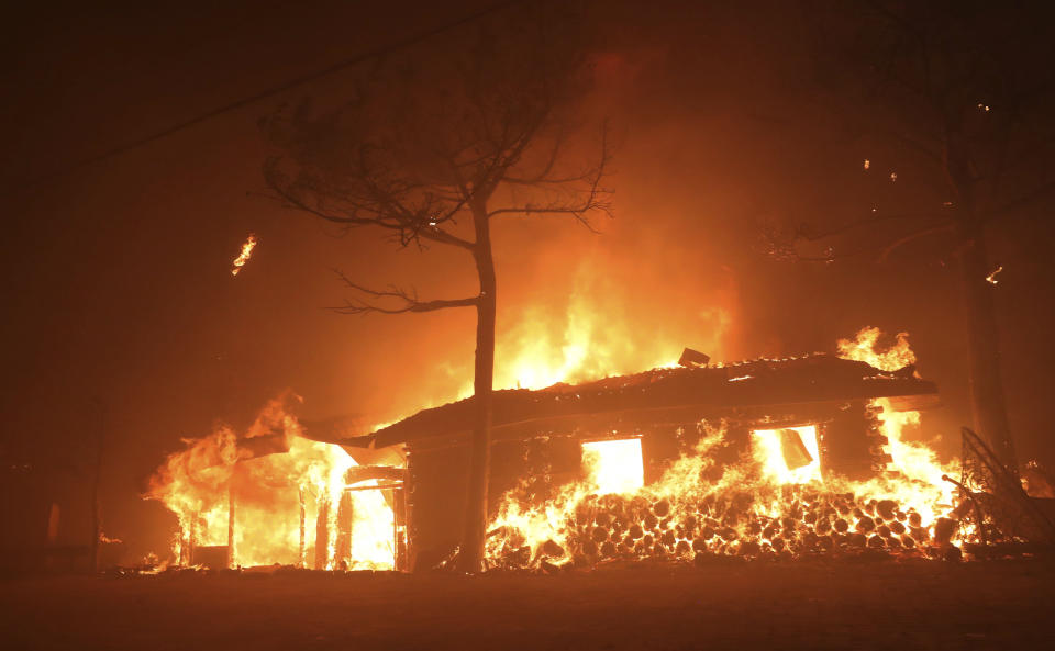 In this Thursday, April 4, 2019 photo, a house burns in Goseong, South Korea. A few people died and thousands were evacuated after strong winds fanned a large fire Friday burning in a mountainous South Korean province that hosted the 2018 Pyeongchang Winter Olympics, officials said. (Yang Ji-ung/Yonhap via AP)