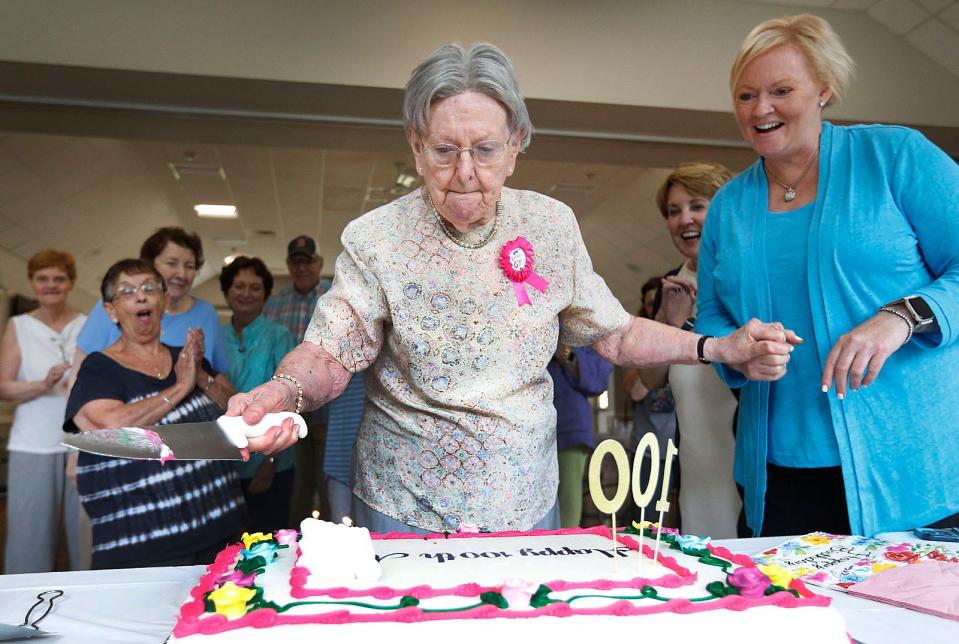 Mary "Mae" Ryan, of Milton, uses a knife to put out the flames on her birthday candles as she celebrates her 100th birthday with friends at the Milton Senior Center after her weekly card game Monday, July 18, 2022. At right is Christine Stanton, director of the Milton Council on Aging.