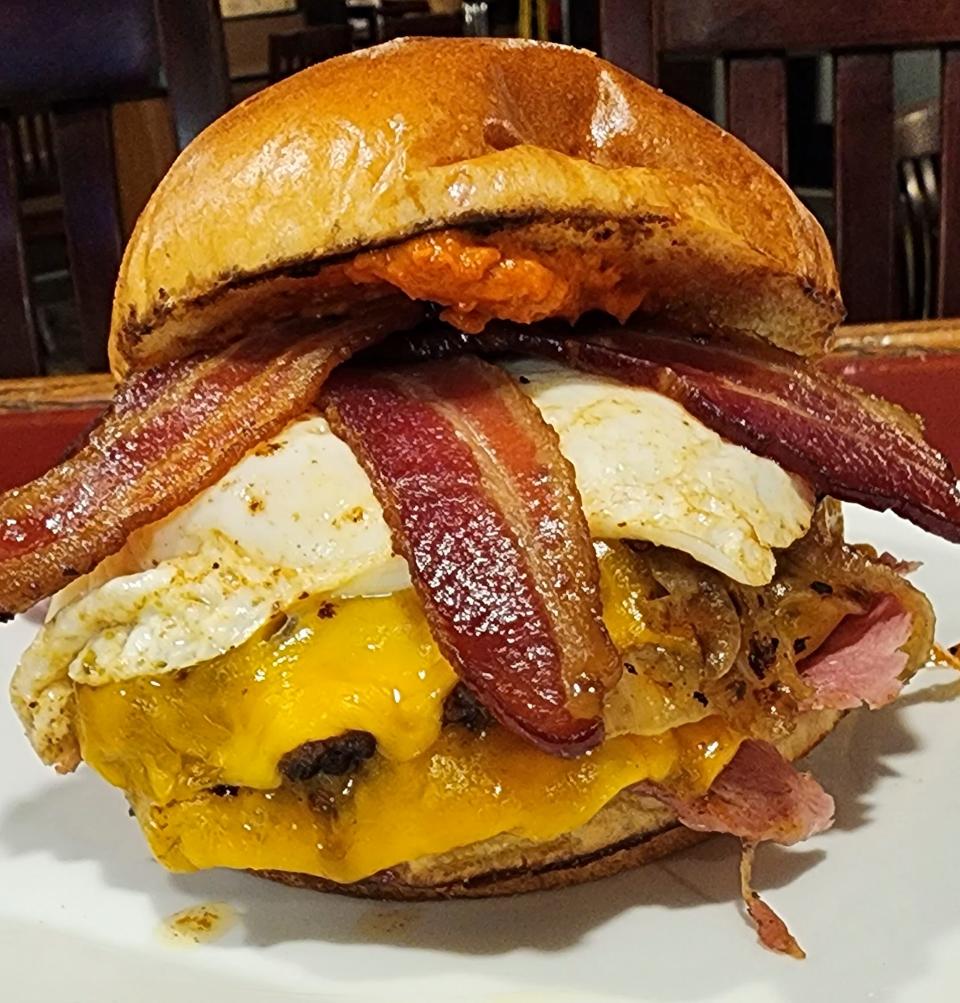 The Hangover burger at Arms & Embers Grill includes bacon, ham and an egg.