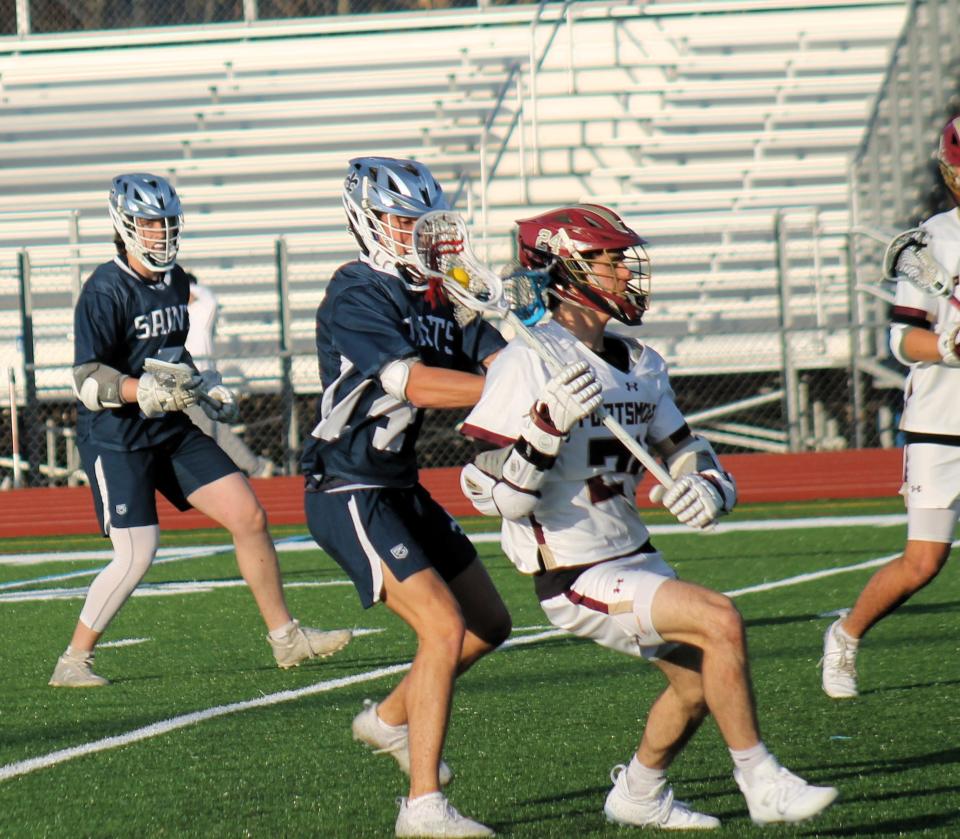 Portsmouth's Zac Amend, right, looks for an opening despite tight coverage during Monday night's Division II boys lacrosse game in Portsmouth.